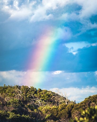 A vertical shot of the beautiful rainbow in the blue sky. Cape Schanck, Victoria, Australia.