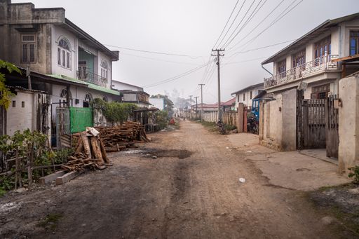 View down a dirt road in the township of Hsipaw, located in the Shan State of Myanmar (Burma), on a foggy morning.