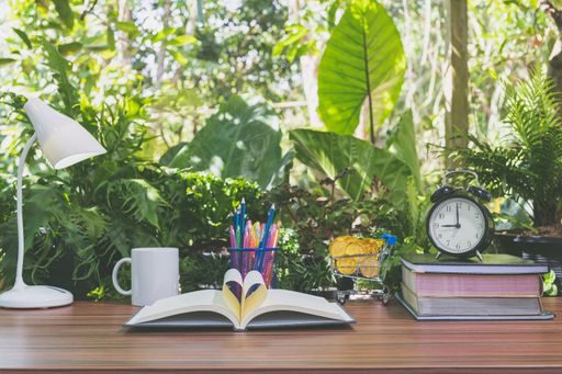 A stationery set with clock and desk lamp on a table outdoors