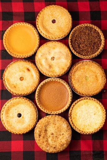 A vertical top view of a variety of mini tarts and pies