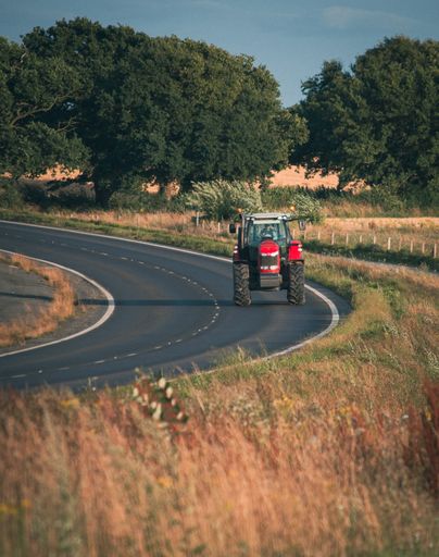 A vertical shot of a tractor on a rural road