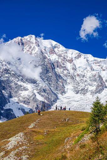 A beautiful shot of hikers with the snowy Mont Blanc mountain in the background on a sunny day