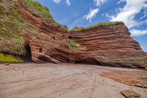 The smuggler tunnels at Horse Cove in Dawlish against a cloudy sky in the United Kingdom