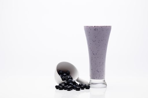 A closeup of Jamun milkshake shot on a white background
