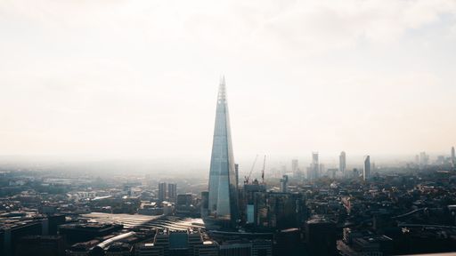 A wide distant shot of the Shard skyscraper surrounded by buildings  in London, England