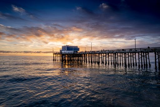 A mesmerizing scene of the pier at Newport Beach under sunset dramatic sky, California