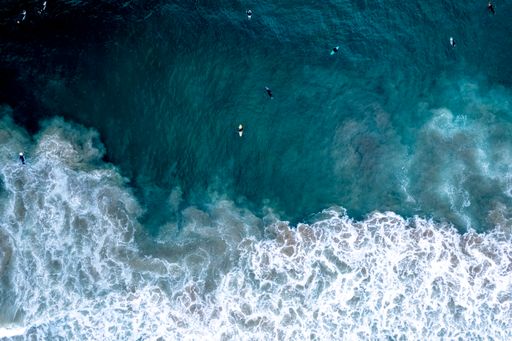 An aerial view of surfers riding the waves in Newport Beach, California