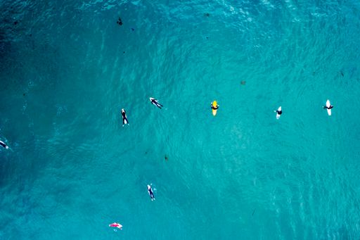 An overhead drone shot of surfers in Newport Beach, California, USA