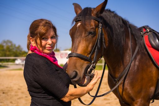A Caucasian adult female posing with a horse