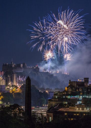 A Beautiful night view of city lights and a colorful firework in the background