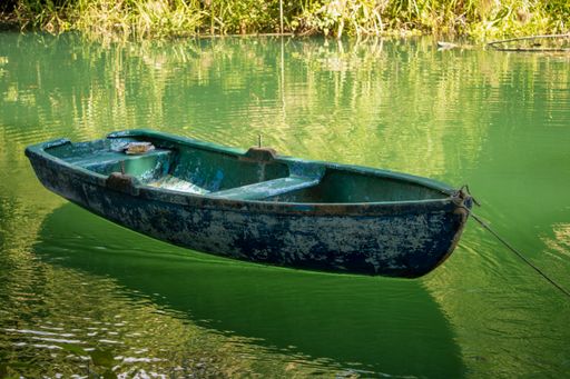 An old painted kayak in a river in La Arboleda protected area, Matanzas, Cuba