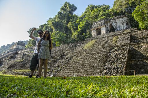 A male and a female posing in front of an old historic building in the lost Mayan city of Palenque in Mexico