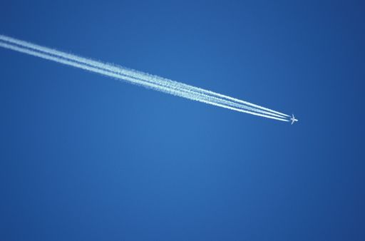 A low angle shot of an airplane flying in a clear blue sky in Austria.