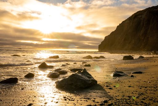 A beautiful shot of a bright sunset over a rocky seashore