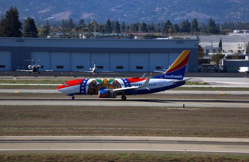 Boeing 737-700 in Missouri One livery lands at San Jose Airport with Santa Cruz Mountains in the backdrop.