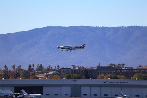 Pilatus PC-12 NG aircraft takes off from San Jose airport with mountains in the background