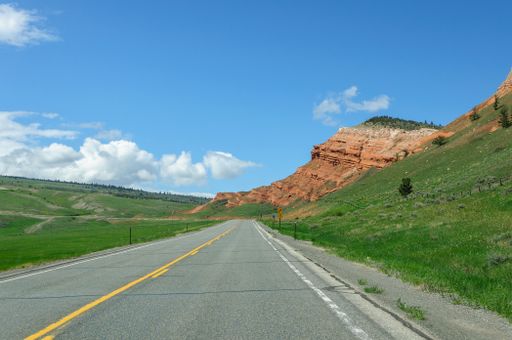 A road in a rural area on a sunny, cloudy day