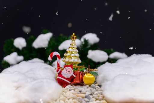 A Closeup of Christmas gifts and decorations with a  snowy background and bokeh lights