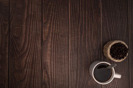 A top view of coffee mug and coffee beans on the table