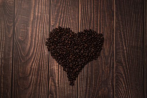 A top view of heart-shaped roasted coffee beansson the table
