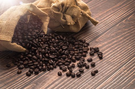 A roasted coffee beans from a burlap sack on the table