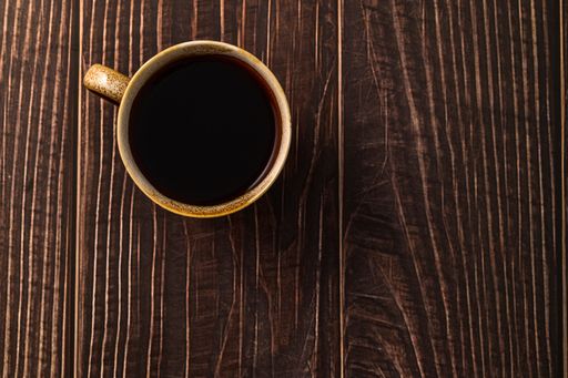 A top view of black coffee on a wooden table
