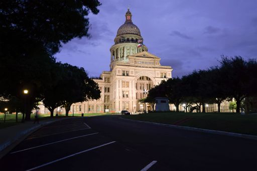 A view of the Texas State Capitol building gleams at dusk.