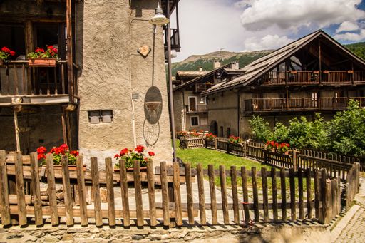 Charming alpine village with rustic wooden houses and vibrant flowers under a clear sky
