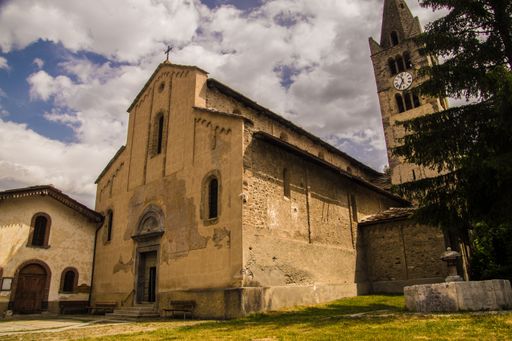 Historic church with clock tower under a cloudy sky, showcasing medieval architecture.