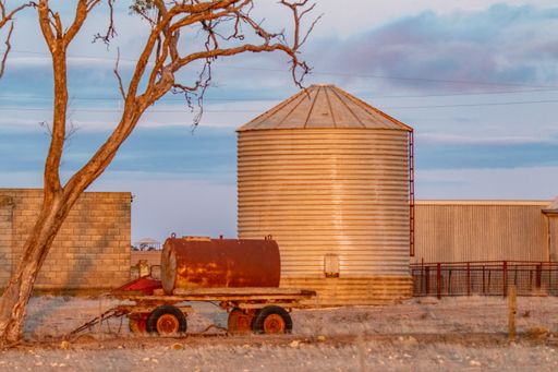 A rural scenery with a silos tower at sunset