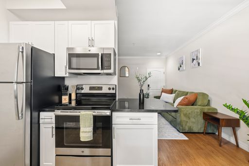Bright open-concept kitchen with center island, built-in appliances, light wood cabinetry, and clean modern finishes. Bright open-concept kitchen