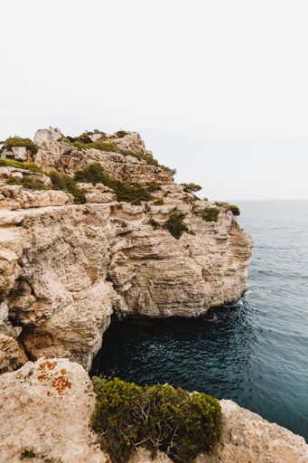 A vertical shot of the cliffs and the blue sea.
