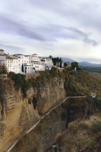 White houses of Ronda in Andalusia, standing dramatically on a cliff overlooking El Tajo Gorge. Located in Malaga, Spain.