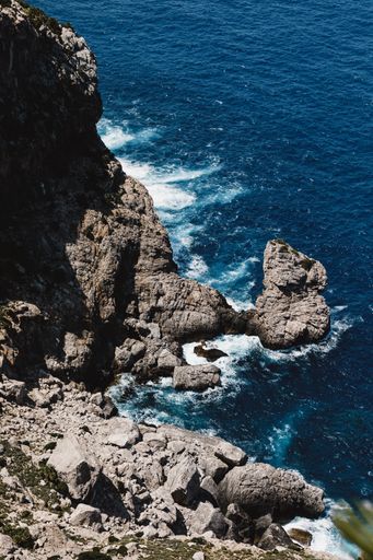 A vertical shot of the cliffs and the blue sea.