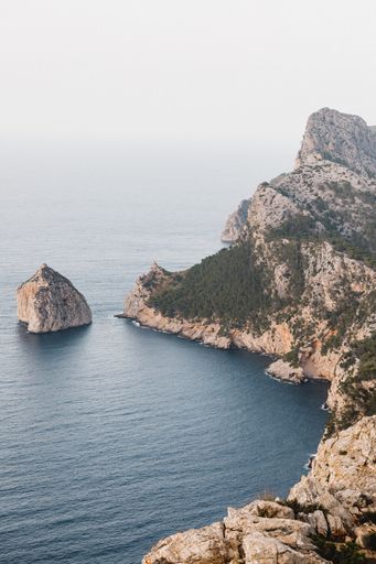 A vertical shot of the cliffs and the blue sea. Mirador Es Colomer, Spain.