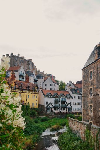Picturesque view of Dean Village, Edinburgh with charming historic buildings and lush greenery.