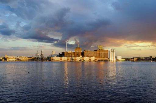 The Domino Sugar factory along the Baltimore Riverfront on the Patapsco River at sunset in Baltimore Maryland USA