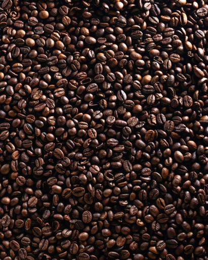 Close-up of roasted coffee beans creating a rich textured background.