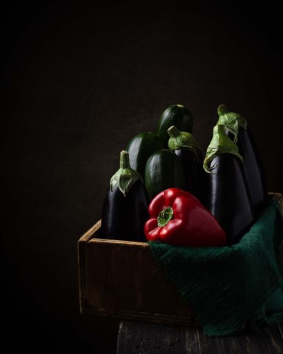 The beautiful, professional shot of red pepper eggplants on the wooden box with perfect lighting