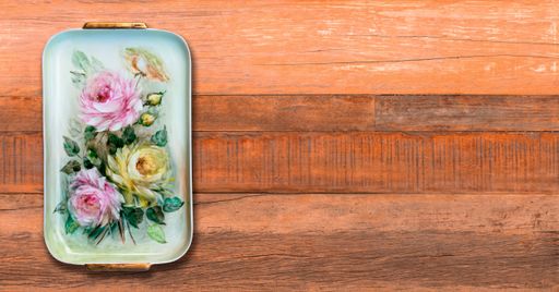 A top view of a colored tray with flowers on a wooden boards surface with a copy space