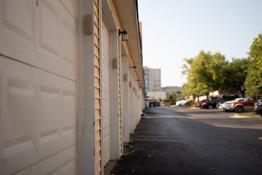 A row of white garages in a car parking area