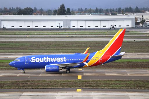 The Southwest Airlines Boeing 737-700 is taxiing to the gates at San Jose International Airport during a cloudy morning