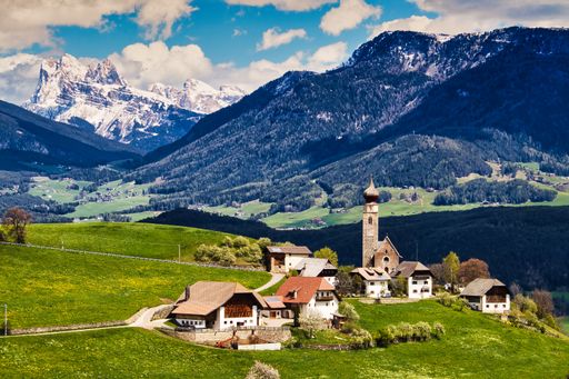 An aerial shot of Lengstein, Italy surrounded by mountains on a sunny day