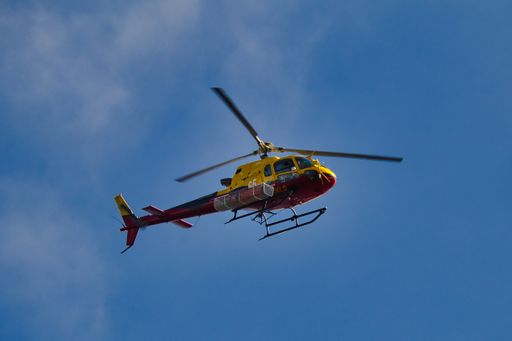 A low angle shot of a flying firefighting helicopter against a blue sky in Cote d'Azur, France