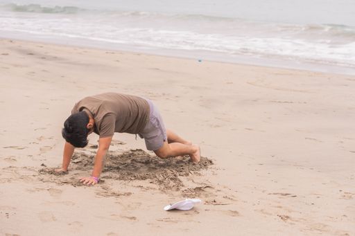 A Young Hispanic man practicing various poses in yoga on the beach