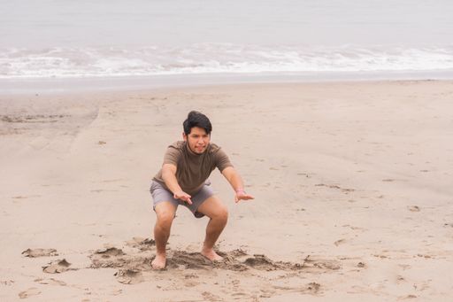 A Young Hispanic man practicing various poses in yoga on the beach