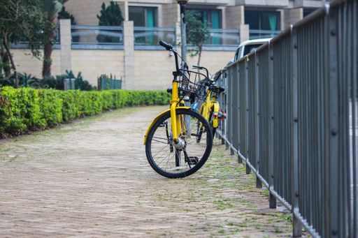 The yellow bicycle parked near the railing.