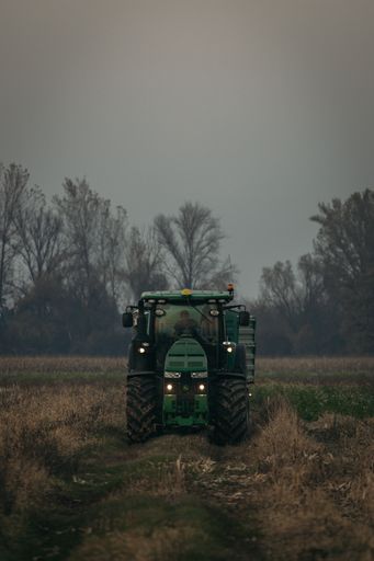 A vertical shot of a John Deere tractor ready to move wheat load in Ludbreg, Croatia