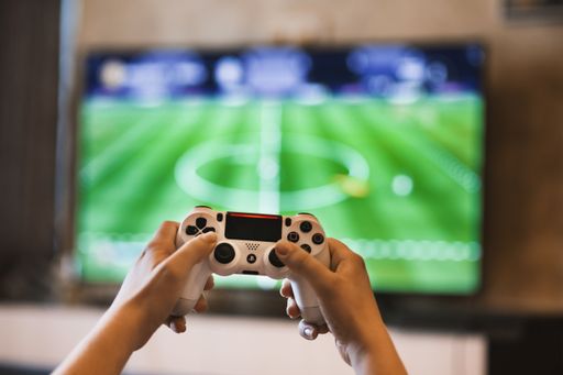 A selective closeup shot of a person holding wireless white gamepad