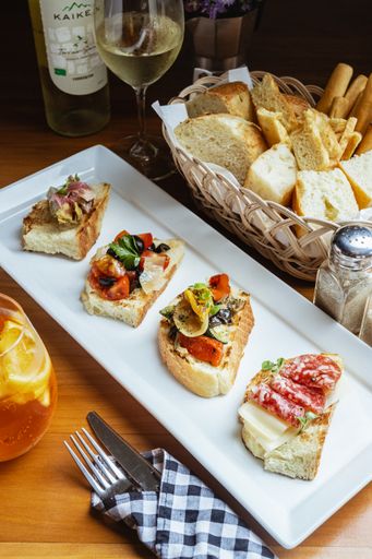 A Closeup shot of an Italian food bruschetta served with white wine at a  restaurant